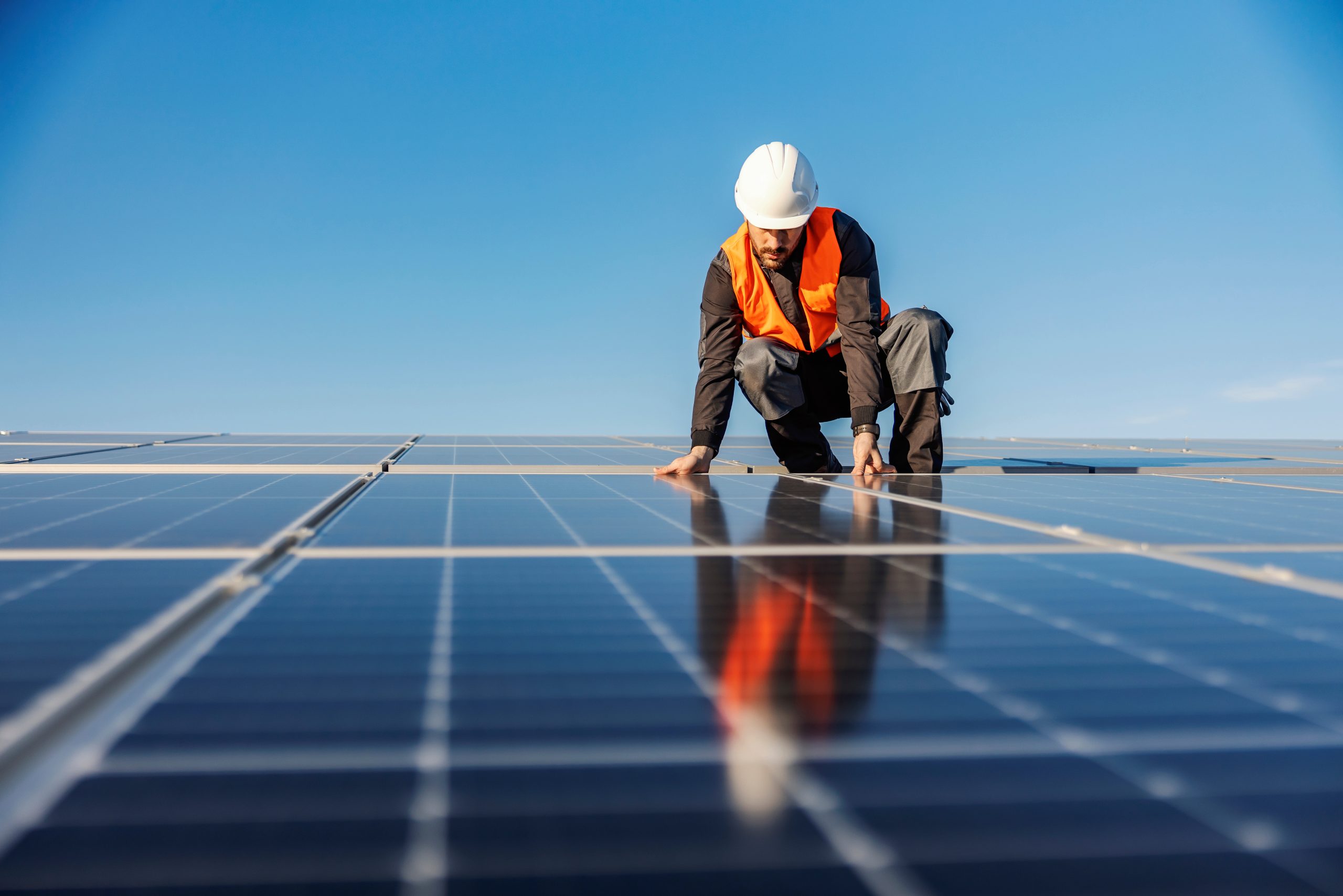 Solar installation worker with solar panels on a roof.